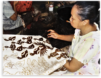 A craftperson designs a batik
