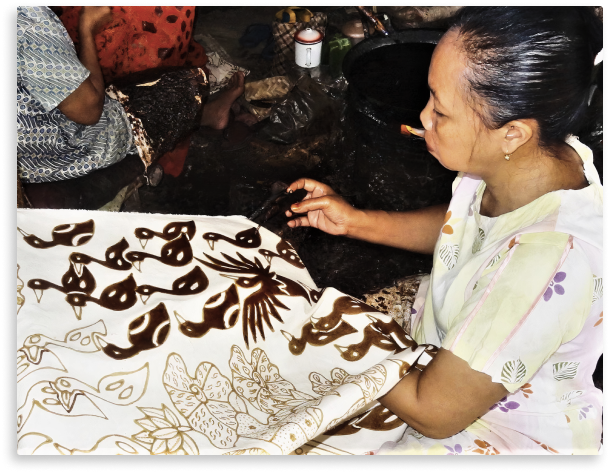 A craftperson designs a batik